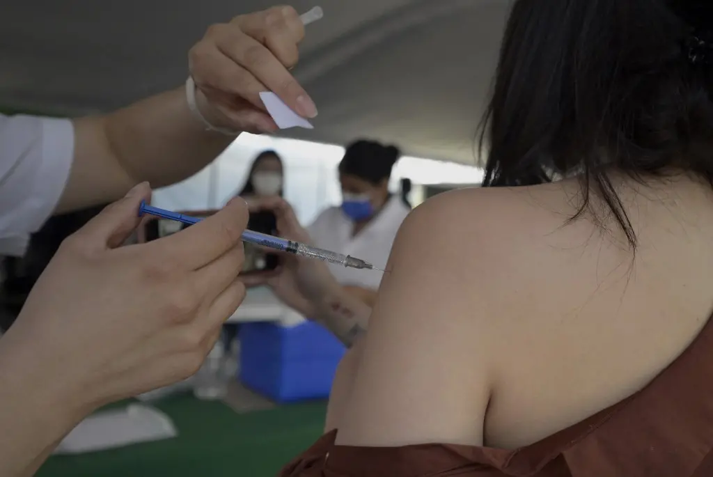 profissional aplica vacina contra a covid-19