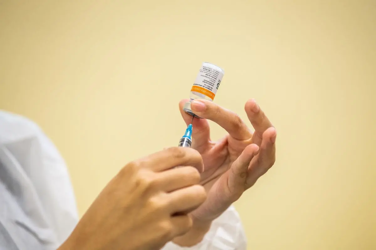 Enfermeira segurando dose da coronavac