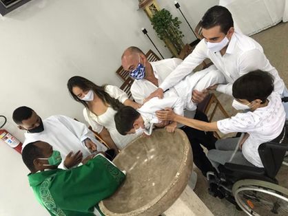 Criança que reclamou com padre sendo batizada na Bahia