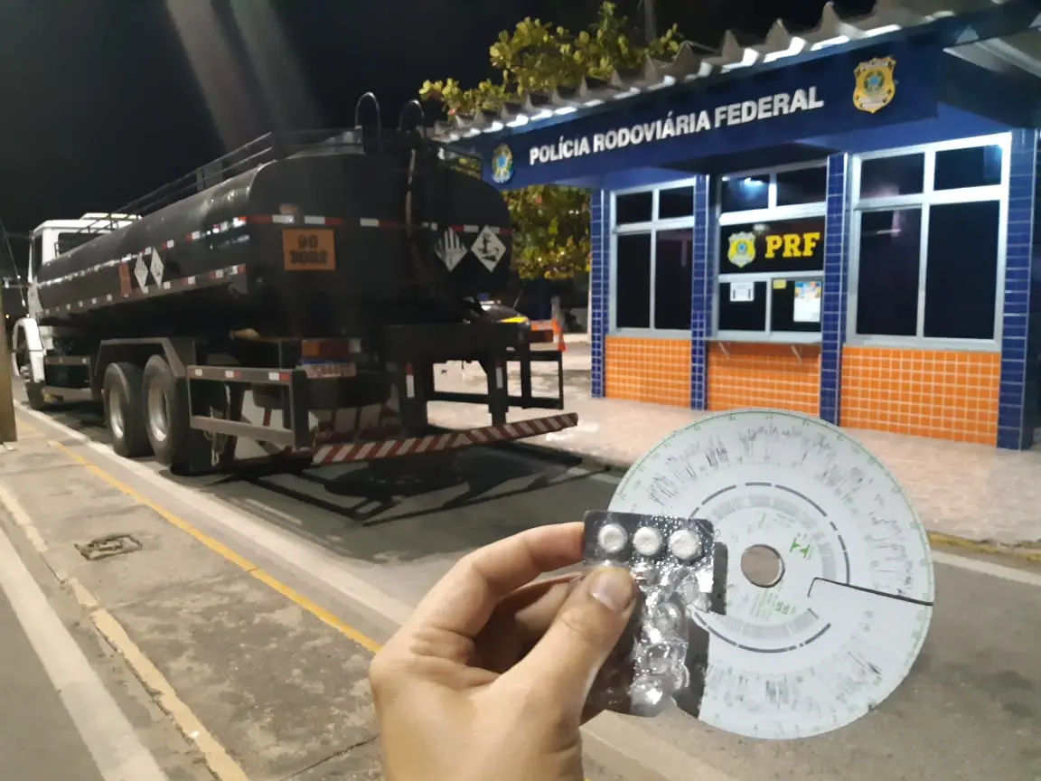 Mão segurando droga apreendida com caminhoneiro e veículo ao fundo