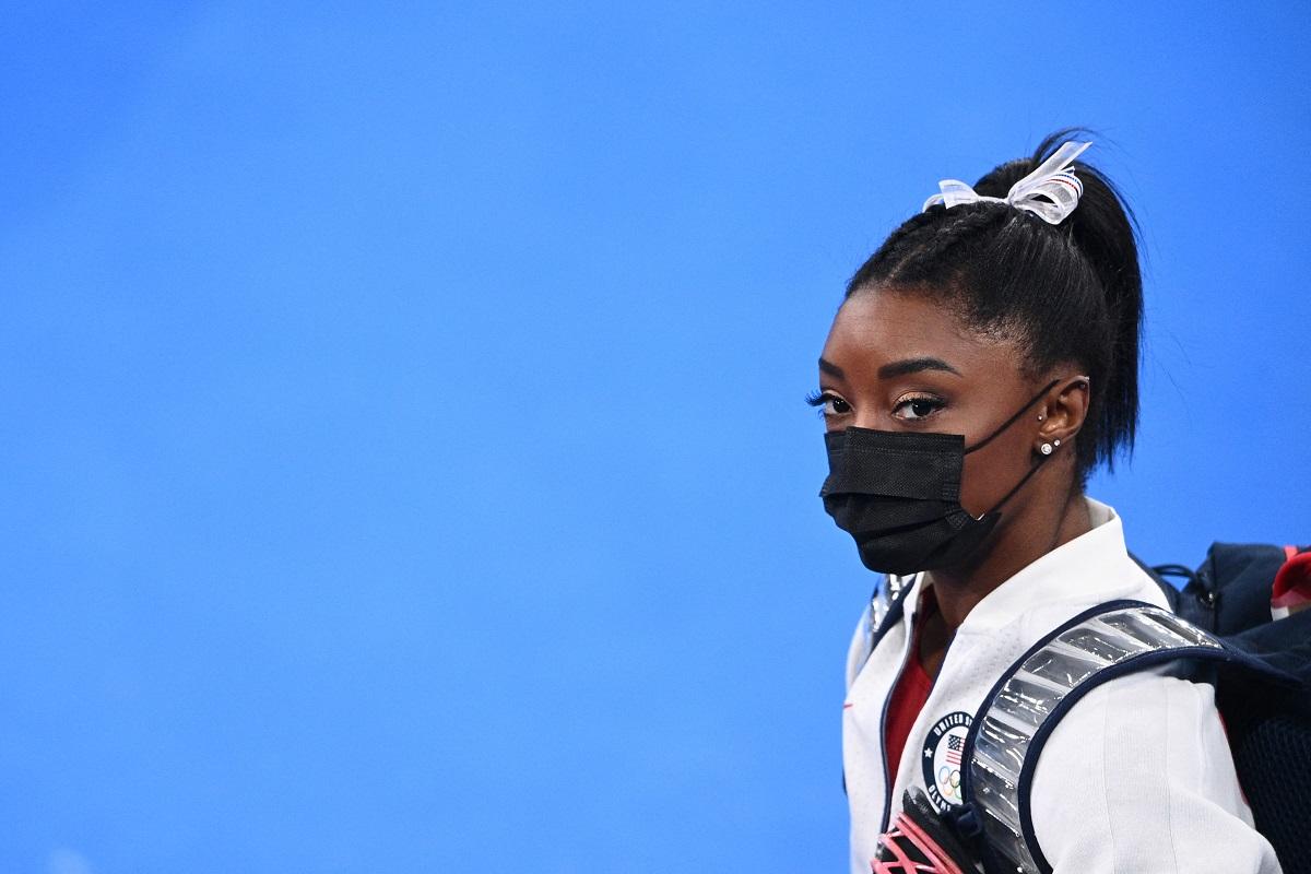Simone Biles de máscara e mochila nas Olimpíadas