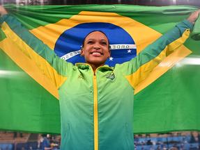 Rebeca comemora conquista da medalha segurando a bandeira do Brasil