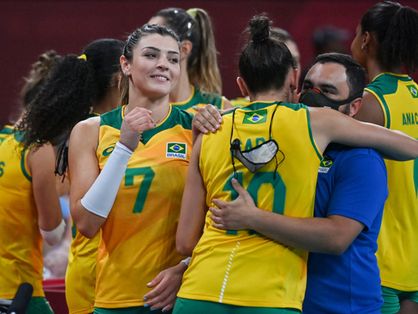 A equipe brasileira de vôlei feminino em quadra comemora