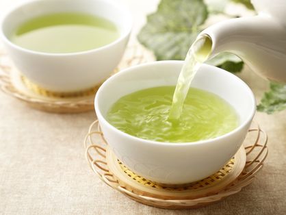 Imagem de chá verde sendo colocado em uma xícara branca