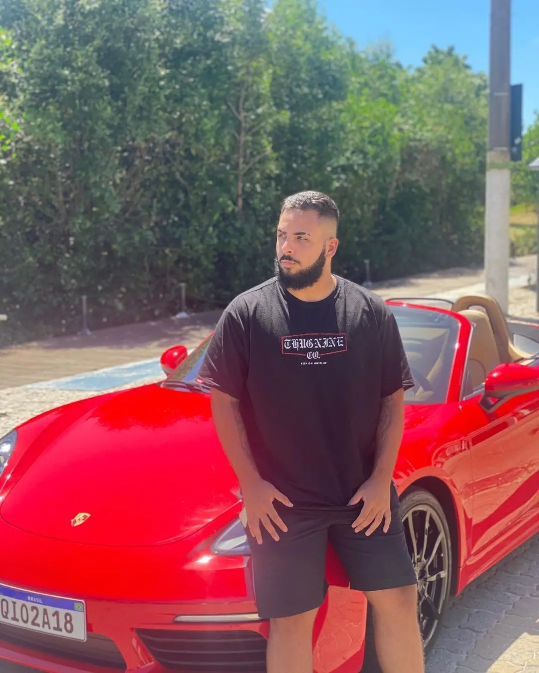 Wesley Pessano ao lado de carro conversível vermelho