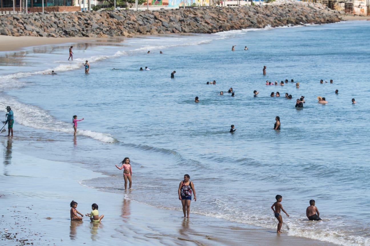 pessoas dentro do mar na praia de iracema