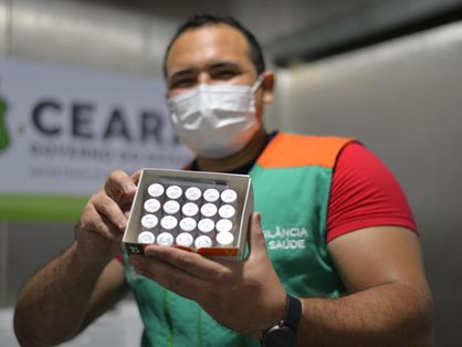 Homem segura frascos da vacina coronavac