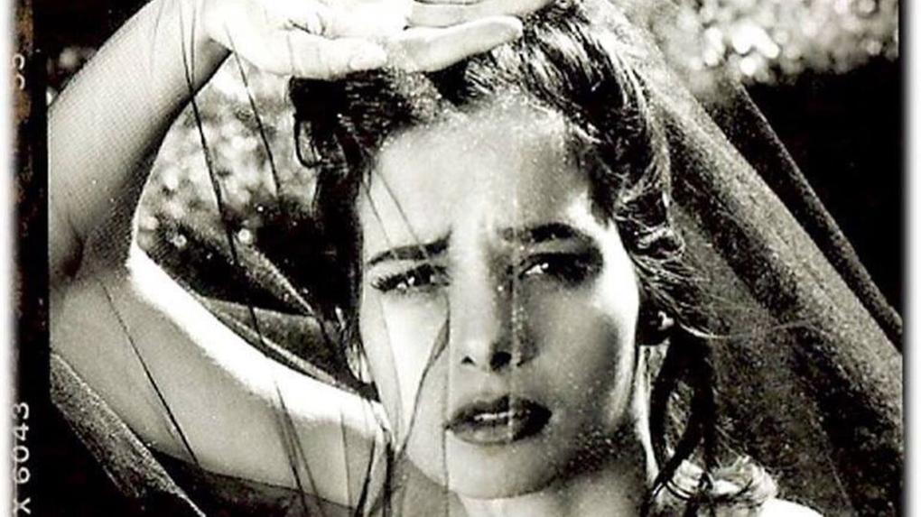 Foto de Daniella Perez em preto e branco. Na foto, a atriz está com braço dobrado e erguido sobre sua cabeça