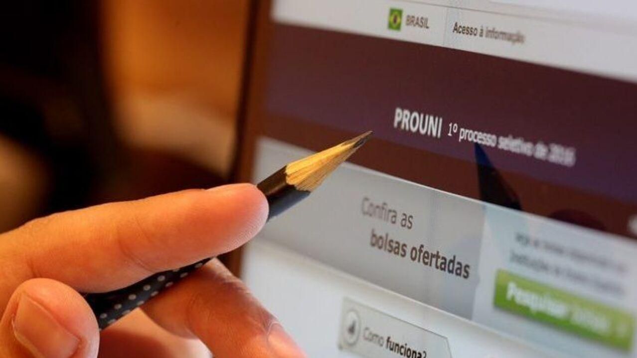 Estudante acessa site do Prouni com lápis de escrever