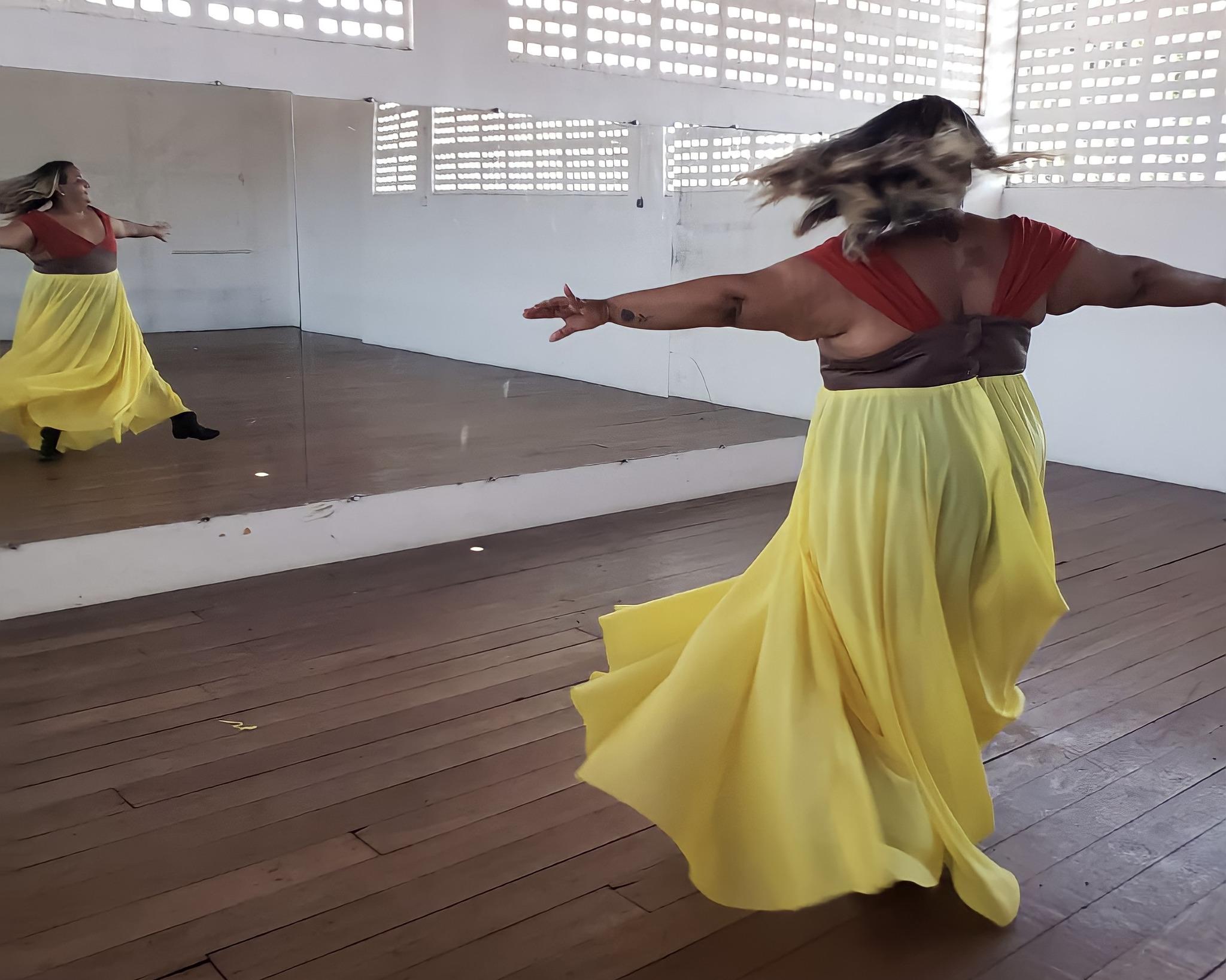 Mulher em frente ao espelho com a roupa da coleção 