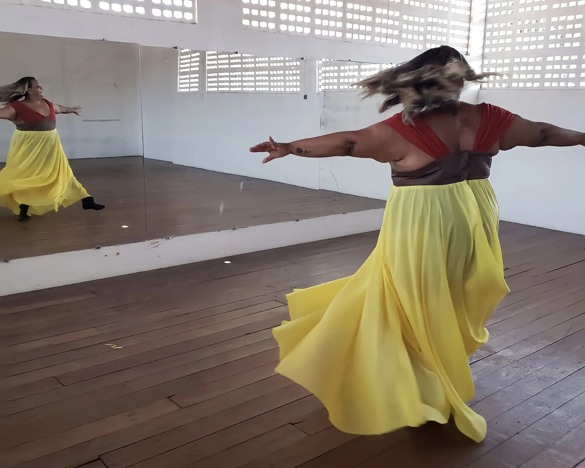 Mulher em frente ao espelho com a roupa da coleção 