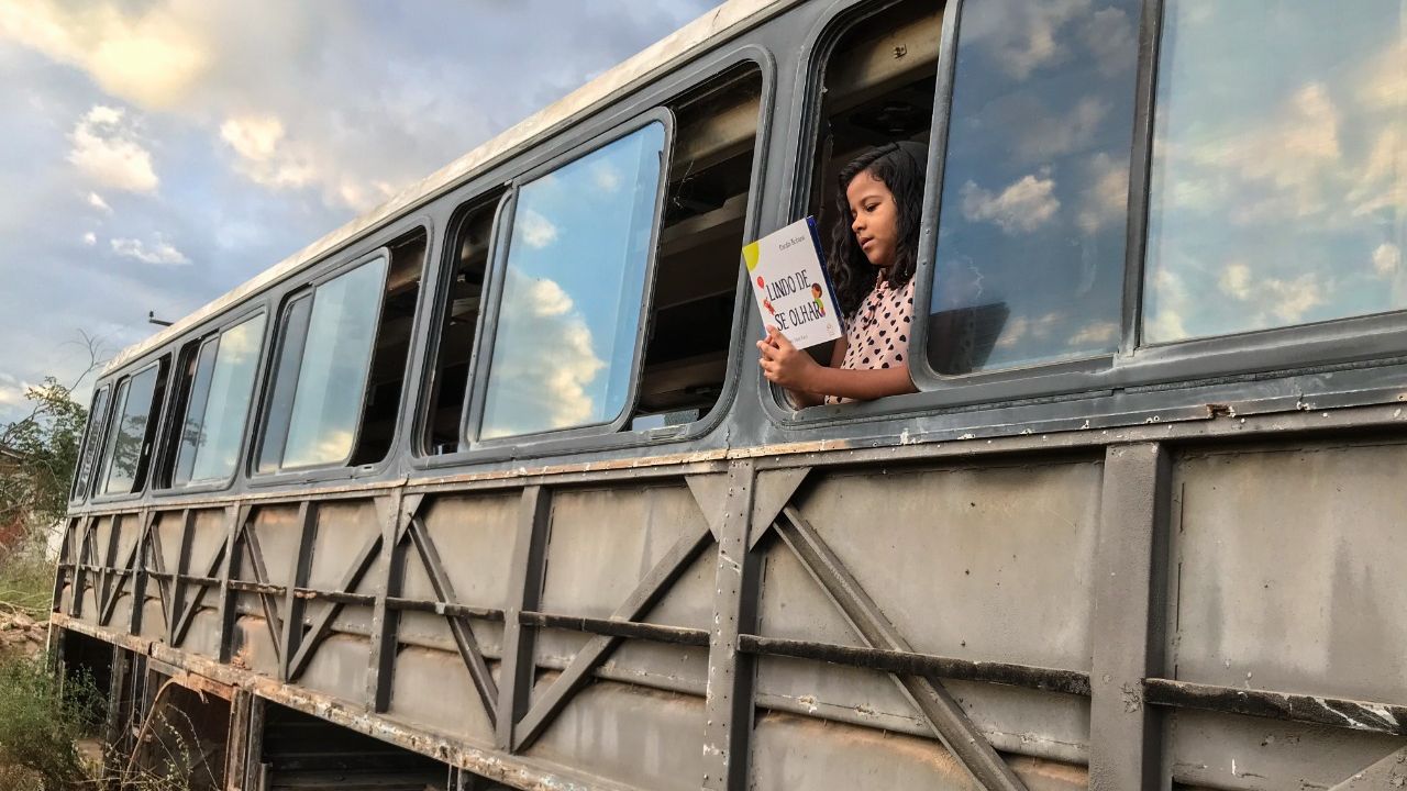 Ana Lívia, 7 anos, lê dentro do onibus-sucata na comunidade de Espinho - Limoeiro do Norte