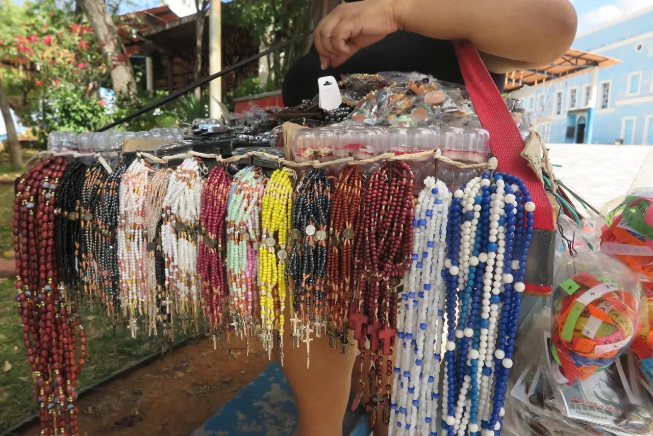 Nas caixas de madeira as “peneiras” oferecem terços, rosários, chaveiros, ímãs de geladeira, entre outros produtos