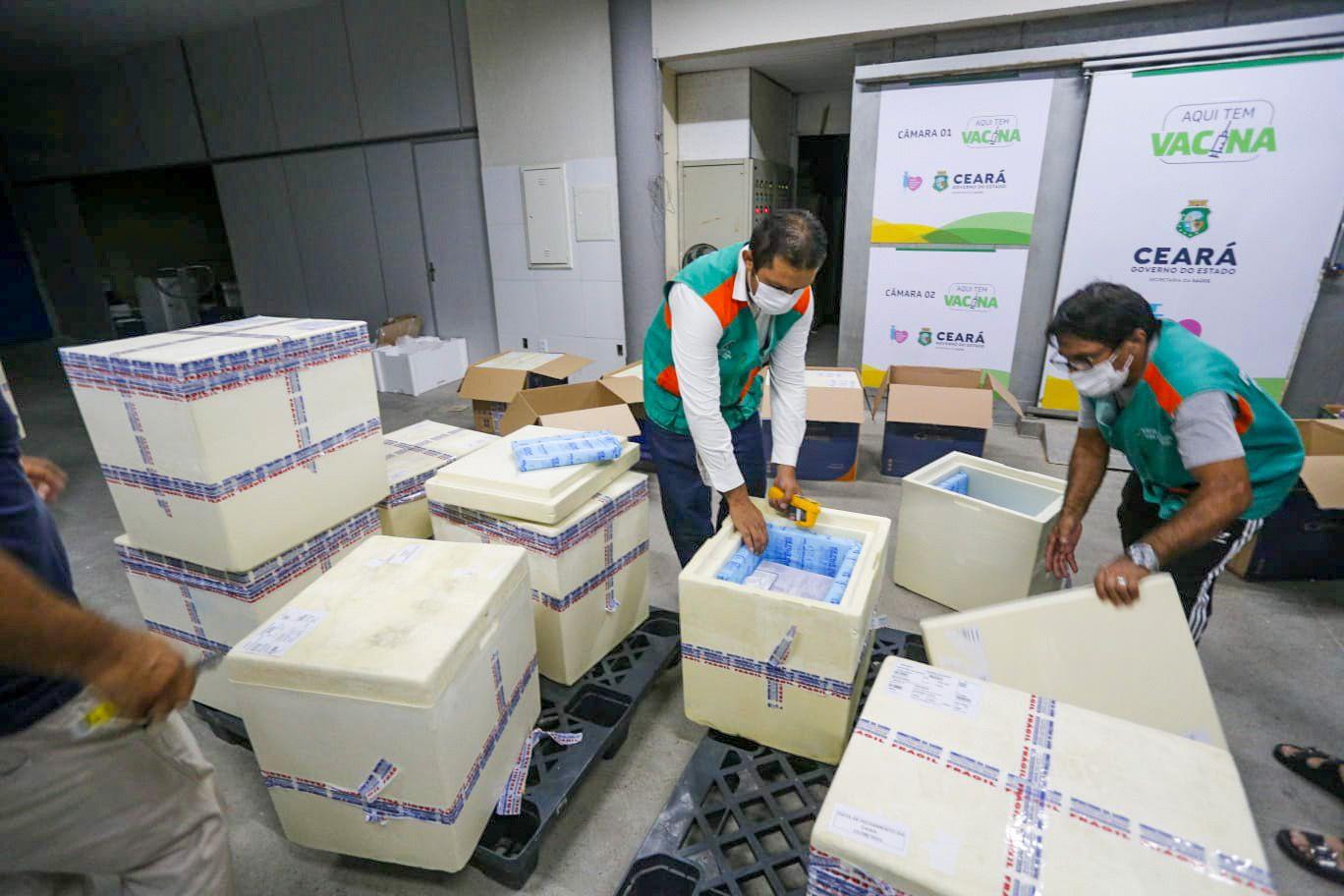 Trabalhadores retirando vacinas de caixas térmicas no Ceará