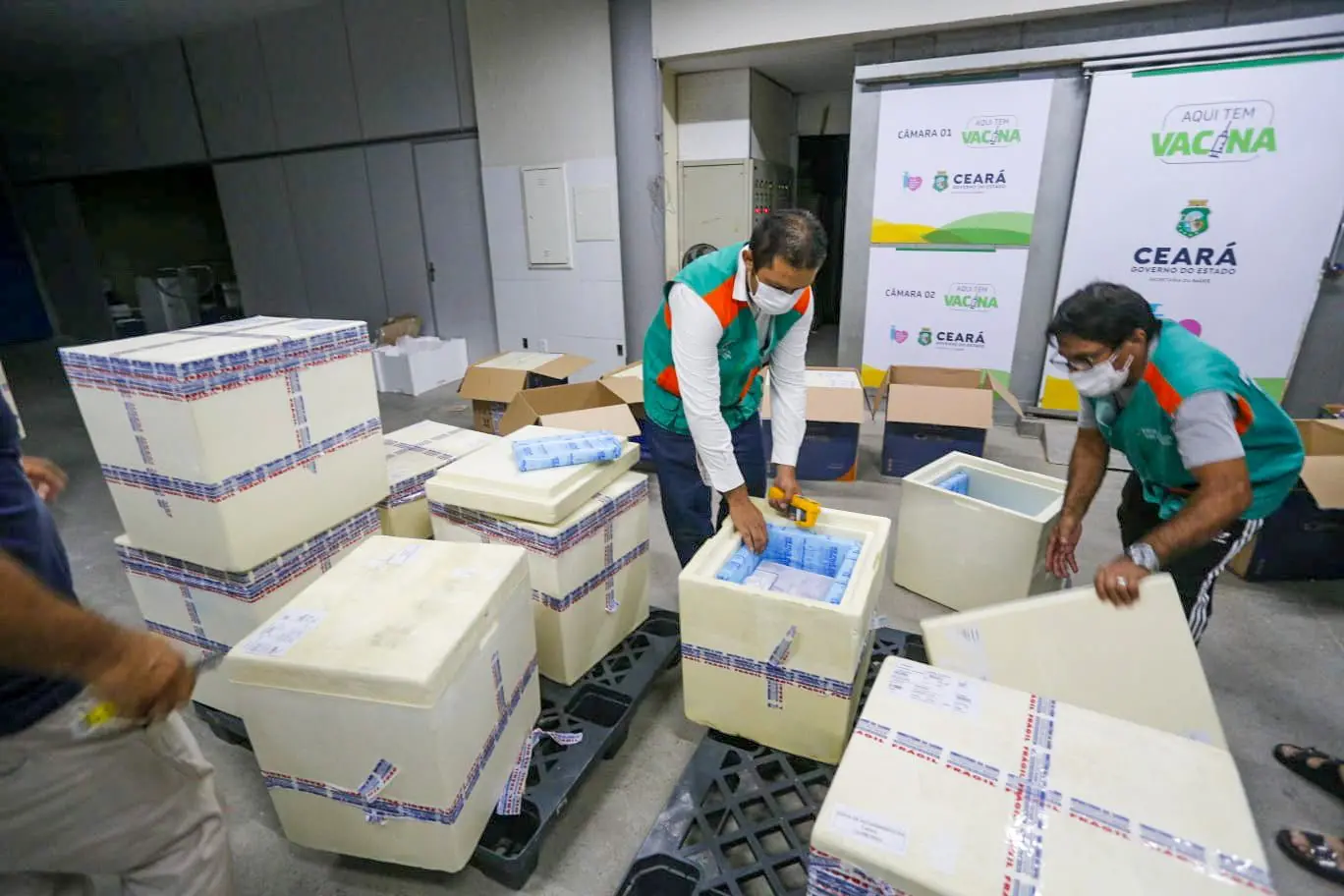 Trabalhadores retirando vacinas de caixas térmicas no Ceará
