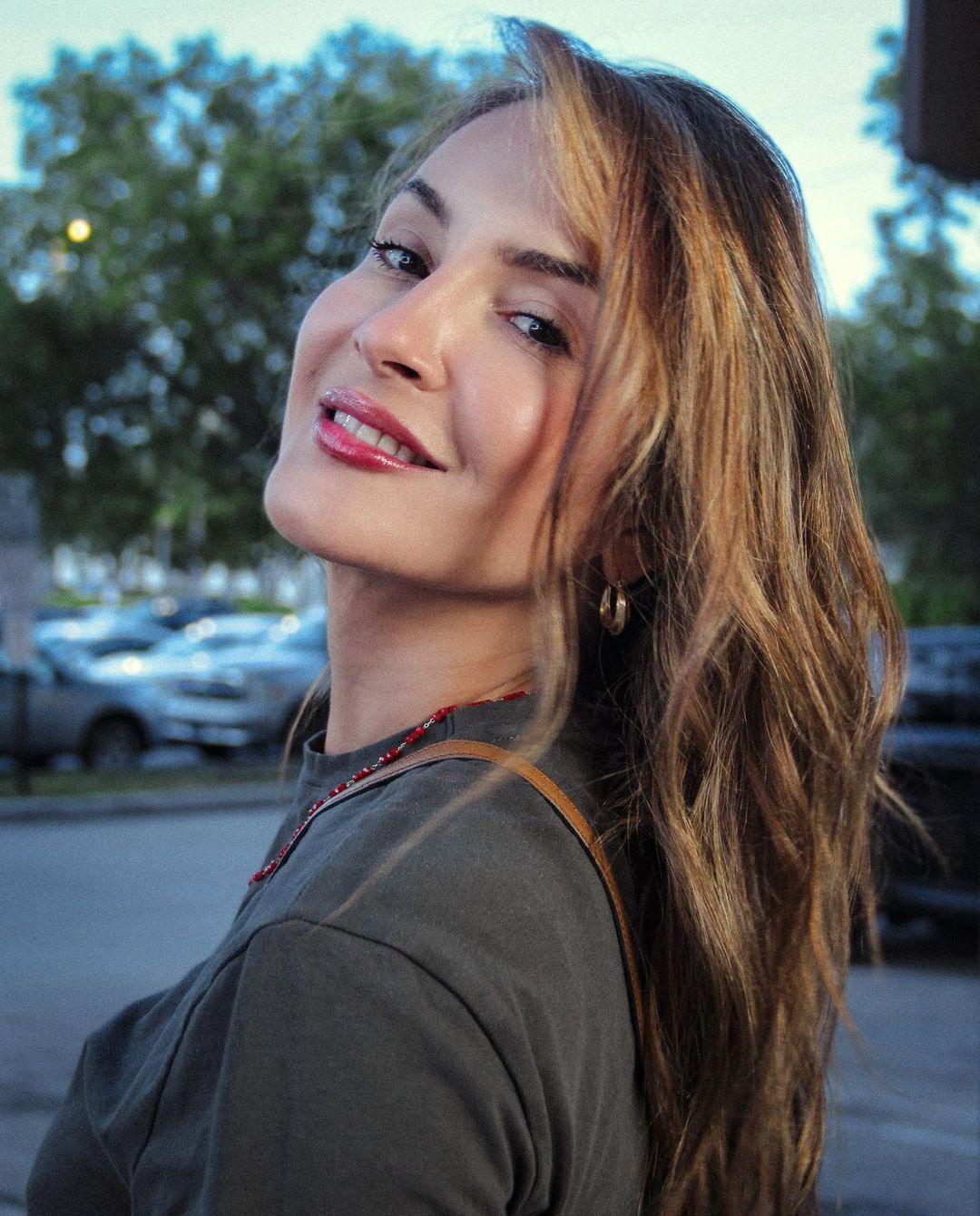 Cláudia Leitte com cabeça pendendo para o lado e blusa preta