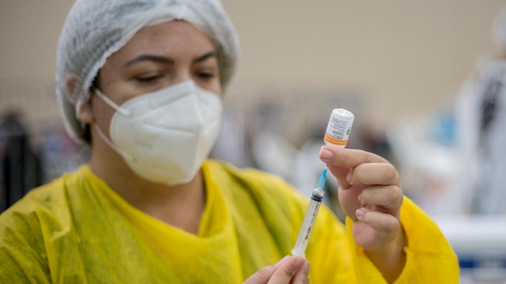 Enfermeira utilizando seringa para aplicar vacina