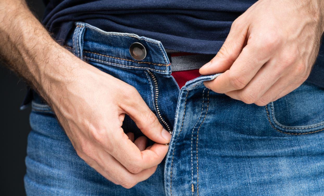 Homem abrindo zíper de calça