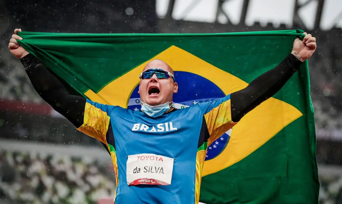 Alessandro da Silva mostra bandeira do Brasil e comera com medalha de ouro