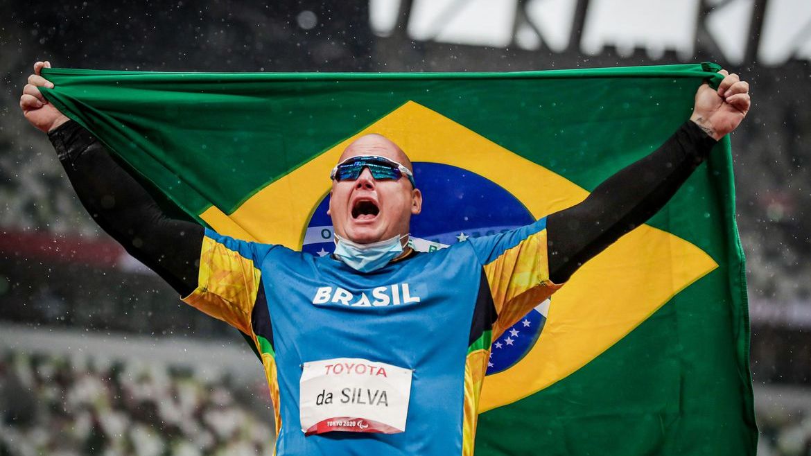 Alessandro da Silva mostra bandeira do Brasil e comera com medalha de ouro