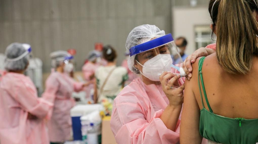 Enfermeira vacinando mulher contra a Covid-19