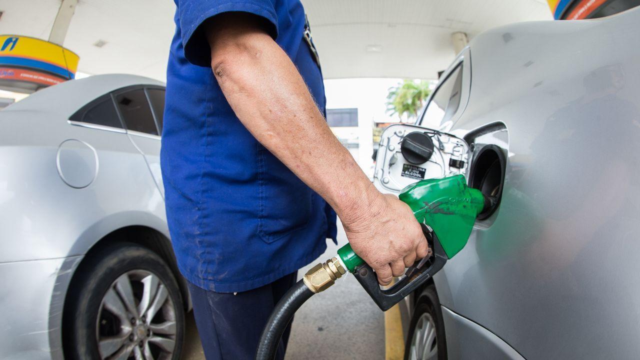 funcionário enchendo tanque de gasolina em posto de combustíveis