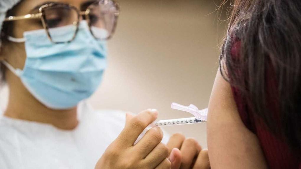 enfermeira aplicando vacina em braço