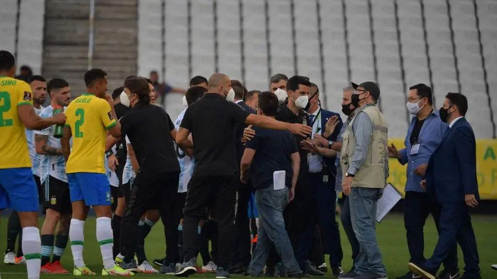 Atletas e agentes sanitários discutem em campo