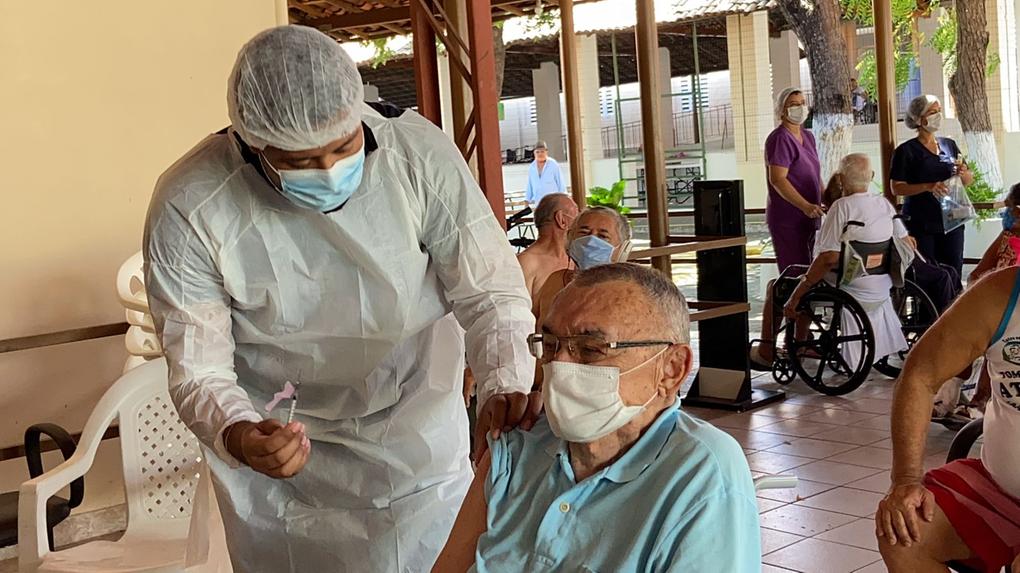 Idoso do Lar Torres de Melo recebendo vacina contra Covid-19 de enfermeiro