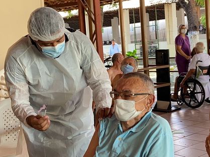 Idoso do Lar Torres de Melo recebendo vacina contra Covid-19 de enfermeiro