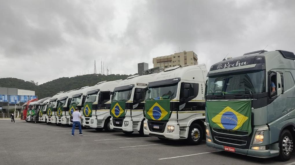 caminhões alinhados, lado a lado, com bandeiras do brasil