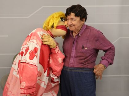 Djacir Oliveira ao lado do boneco de sua personagem do Nas Garras da Patrulha, a Sinira Beiçuda