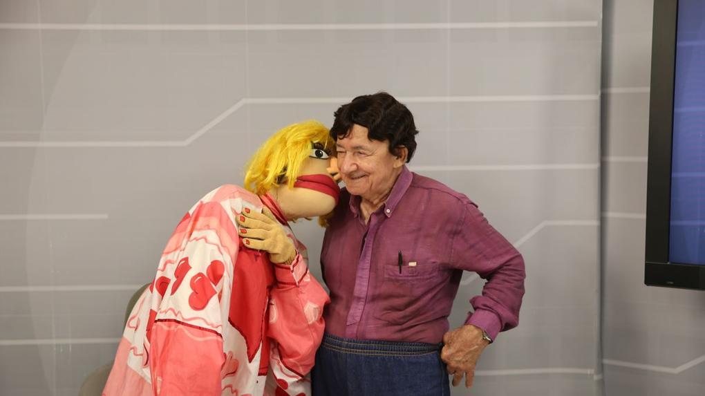Djacir Oliveira ao lado do boneco de sua personagem do Nas Garras da Patrulha, a Sinira Beiçuda