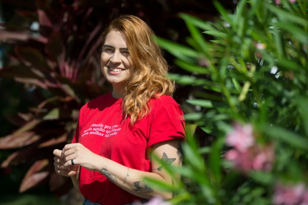 Neyla, que tem bordeline, sorri em jardim.