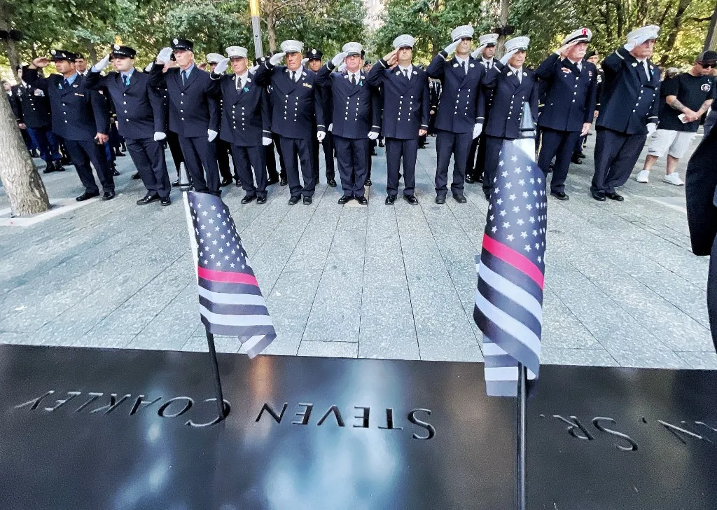 Bombeiros saudam perto do nome de seus colegas mortos durante o Memorial do 20º aniversário no World Trade Center