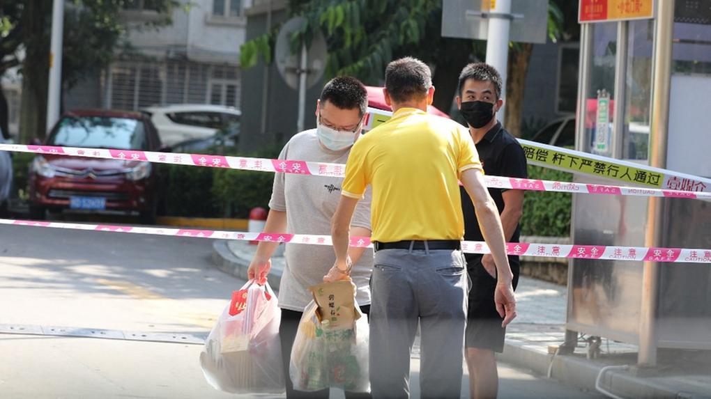 Moradores transferem itens de necessidade em uma área residencial sob rígidas restrições devido a casos de Covid-19 em Xiamen, na província de Fujian