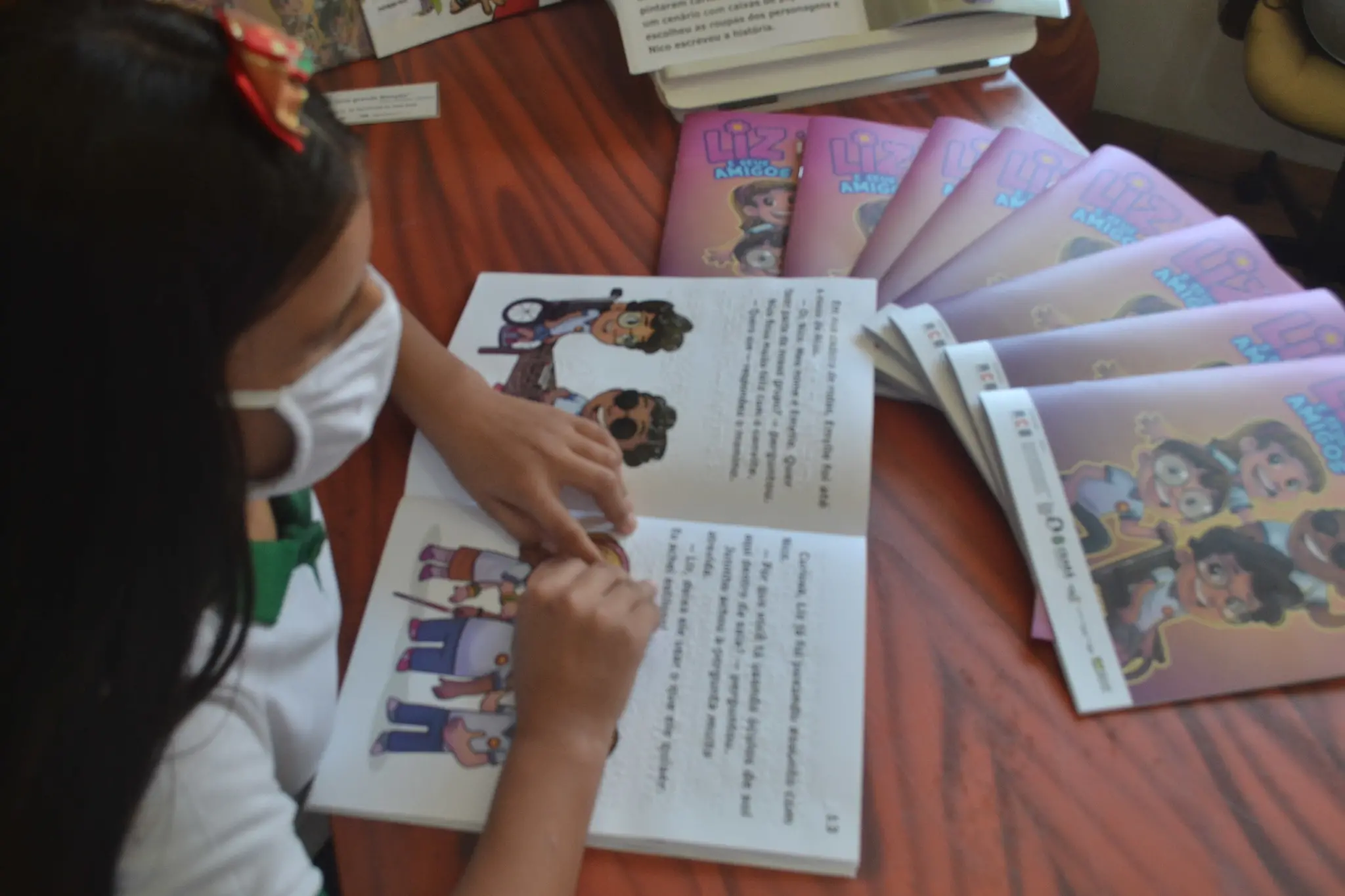Criança com deficiência visual tateia o livro 