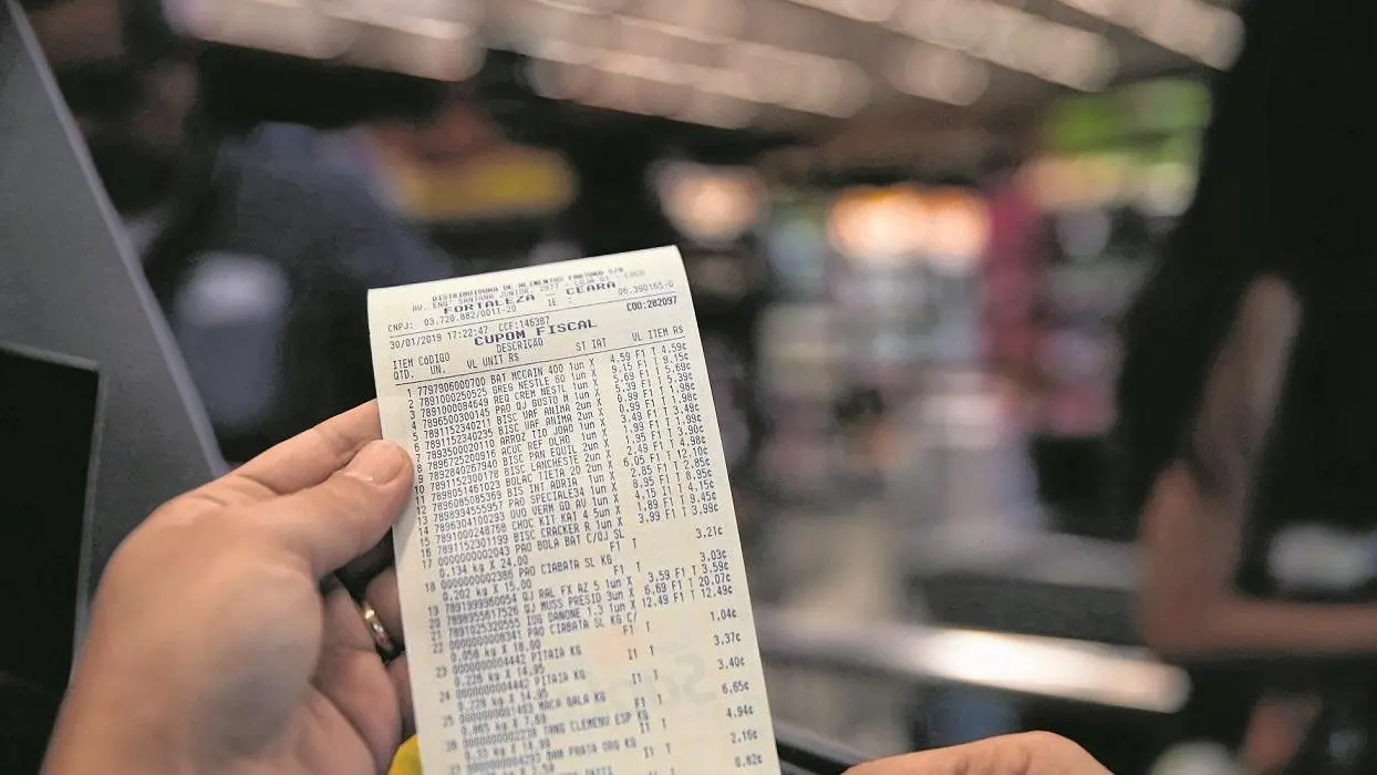 mão segurando nota fiscal