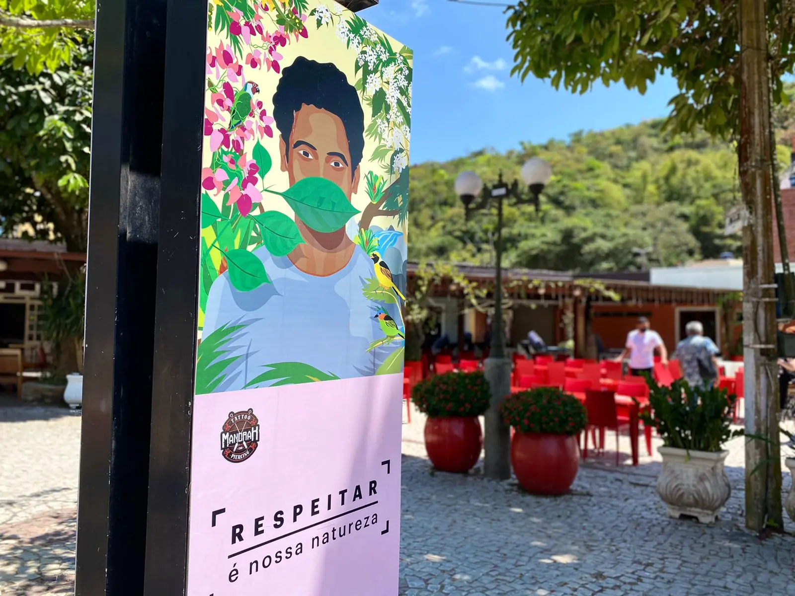 placa no centro de guaramiranga mostra imagem de homem com máscara