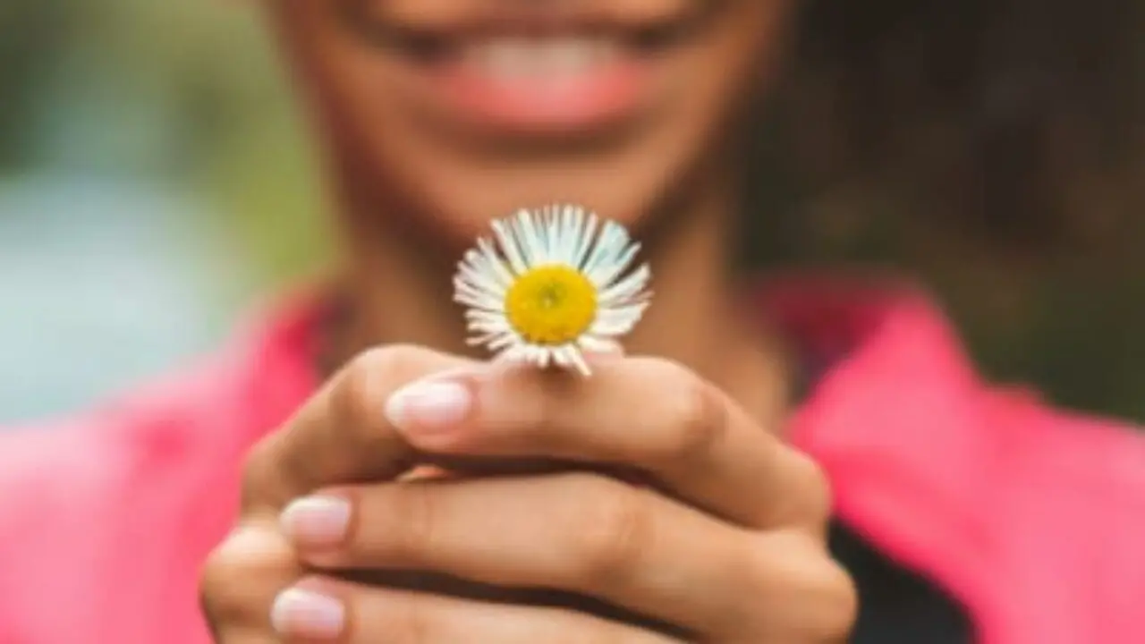 mulher negra segura flor branca