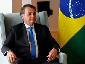 Bolsonaro em evento em Nova York, com bandeira do Brasil do lado dele