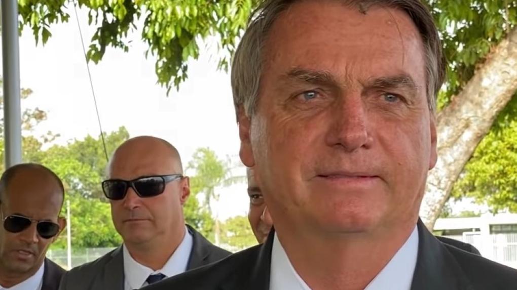 Bolsonaro na saída do palácio do alvorada, com seguranças atrás