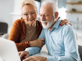 casal de idosos olhando computador