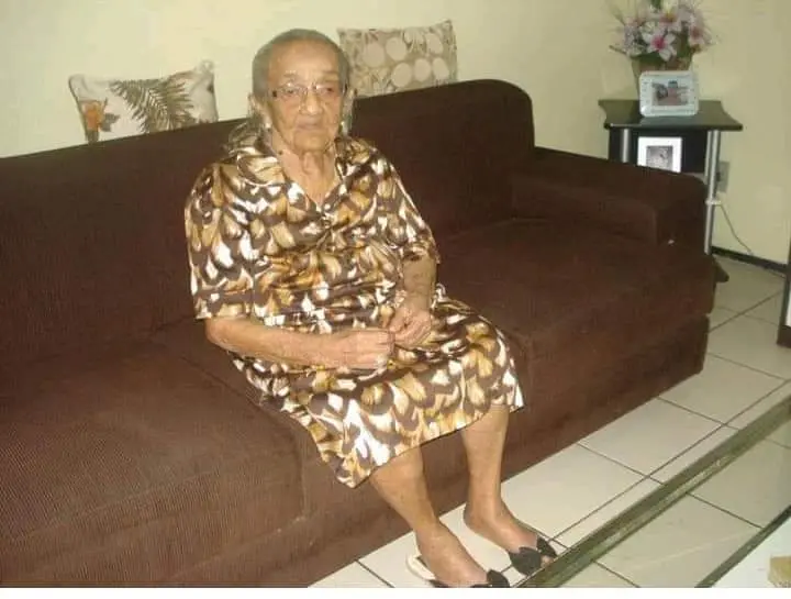 Dona Francisca Celsa sentada em um sofá marrom