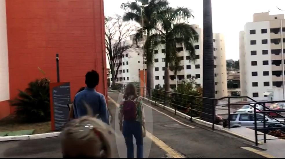 Suzane von Richthofen com mochila nas costas, chegando à universidade no primeiro dia de aula, acompanhada de advogado