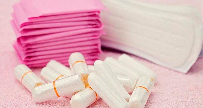 Absorventes em cima de uma toalha rosa