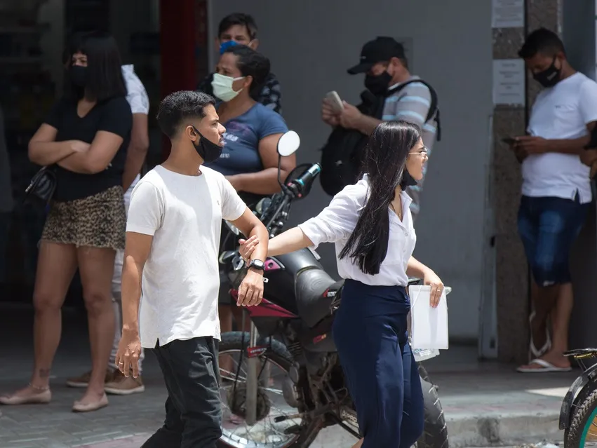 Jovens caminham com uso incorreto da máscara na Avenida Francisco Sá.