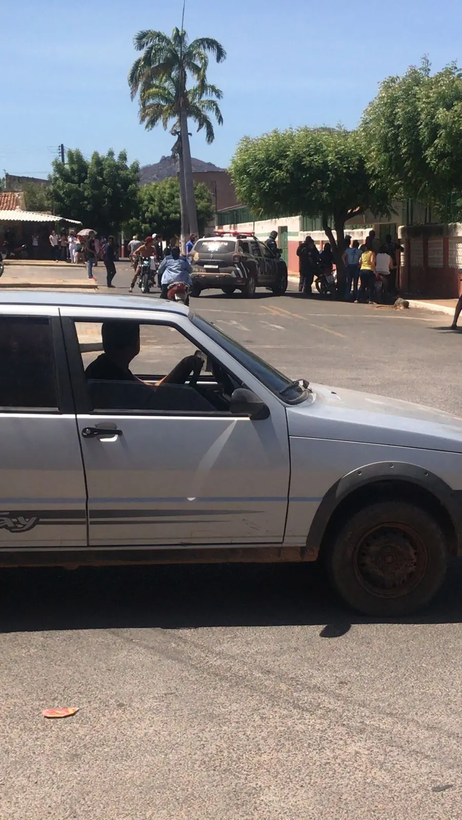 Carro de polícia e tumulto em frente à escola de Mucambo
