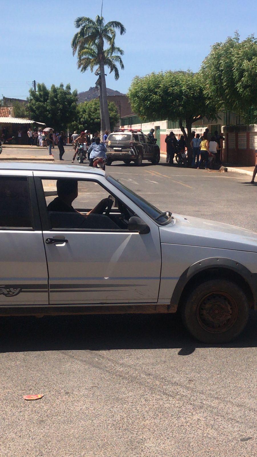Carro de polícia e tumulto em frente à escola de Mucambo