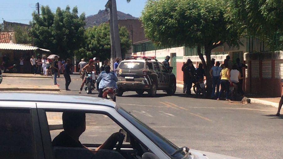 Carro de polícia e tumulto em frente à escola de Mucambo
